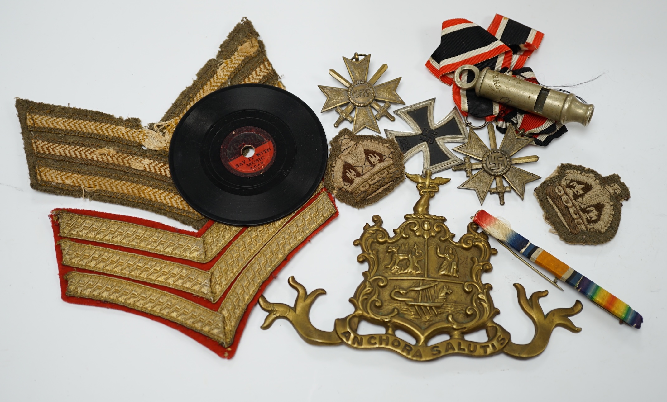 Three WWII German medals; a Second Class Iron Cross and two Merit Crosses, together with a brass naval related crest, a Metropolitan whistle, sergeant’s cloth titles, and other ephemera. Condition - fair